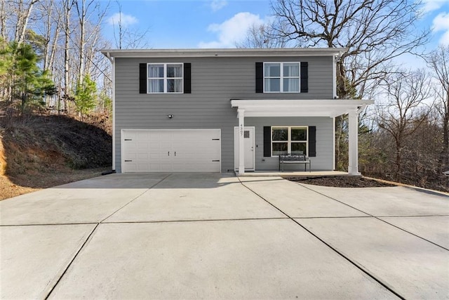 traditional-style home with a garage, covered porch, and driveway