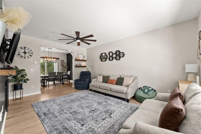 living room with ceiling fan and light hardwood / wood-style floors