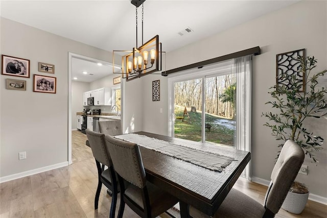 dining area featuring recessed lighting, visible vents, light wood-style floors, a chandelier, and baseboards