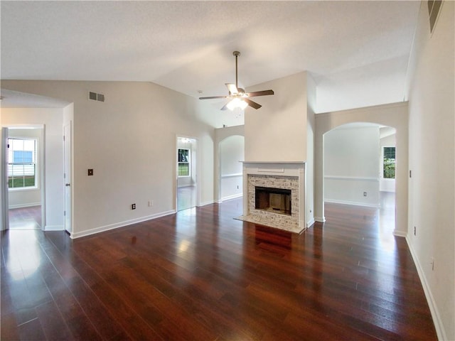 unfurnished living room featuring a fireplace, ceiling fan, dark hardwood / wood-style flooring, and lofted ceiling