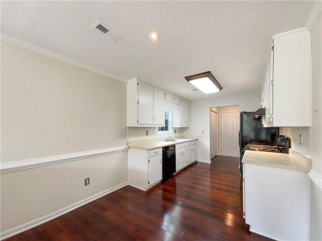 kitchen featuring a textured ceiling, dark wood-type flooring, sink, black dishwasher, and white cabinetry