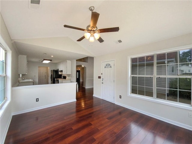 unfurnished living room featuring ceiling fan, dark hardwood / wood-style flooring, and vaulted ceiling