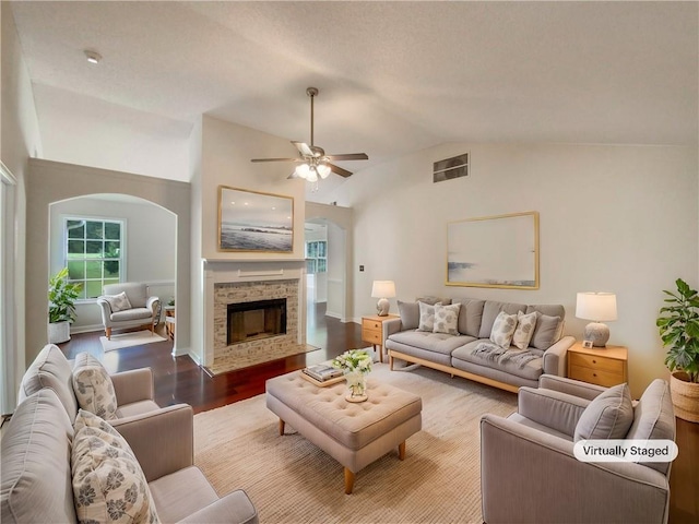 living room featuring ceiling fan, a fireplace, hardwood / wood-style floors, and lofted ceiling