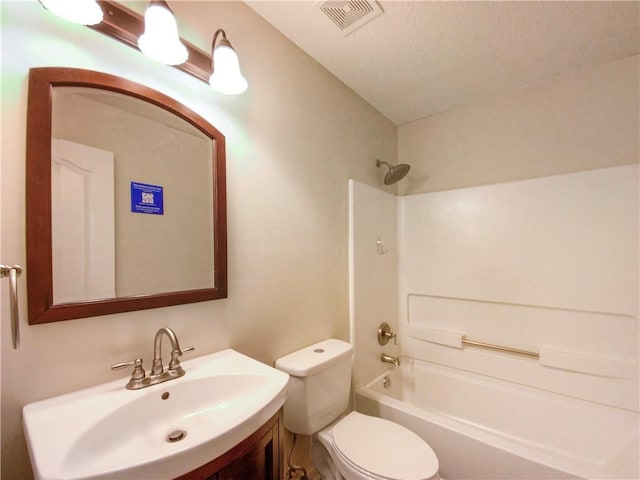 full bathroom featuring vanity, toilet, a textured ceiling, and shower / washtub combination