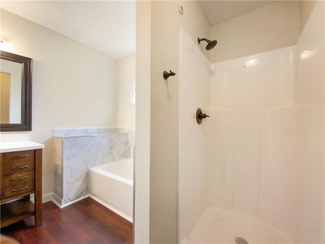 bathroom featuring hardwood / wood-style floors, vanity, and a tub to relax in