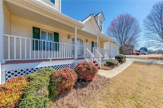 view of exterior entry featuring a garage and covered porch