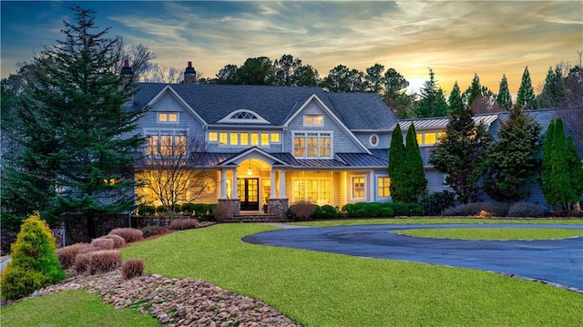 craftsman-style house with a lawn and covered porch