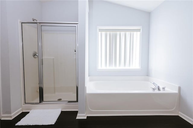 full bathroom featuring a garden tub, wood finished floors, a shower stall, and baseboards