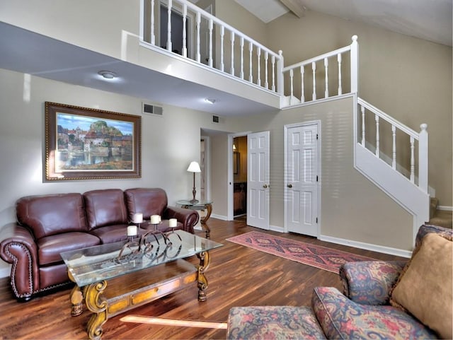 living room featuring beam ceiling, high vaulted ceiling, and dark wood-type flooring