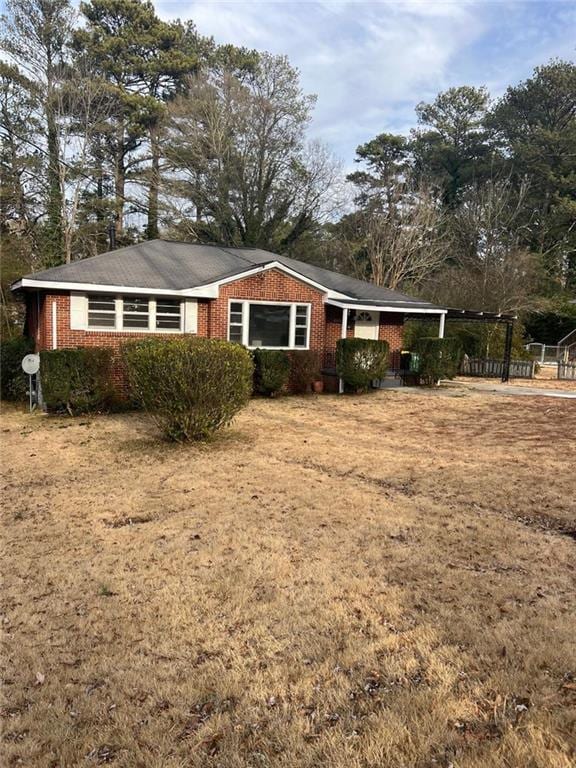 view of front of house with a front yard and brick siding