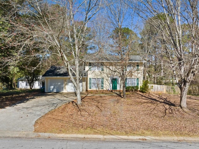 colonial home with driveway, a garage, and fence