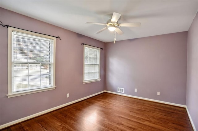 unfurnished room with ceiling fan, dark hardwood / wood-style flooring, and a wealth of natural light