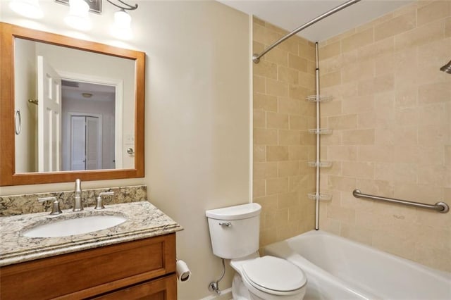 full bathroom featuring vanity, tiled shower / bath combo, and toilet