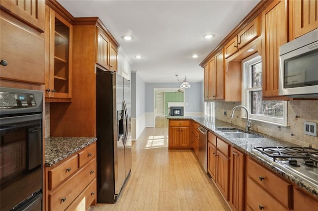 kitchen featuring dark stone counters, stainless steel appliances, tasteful backsplash, and light hardwood / wood-style floors