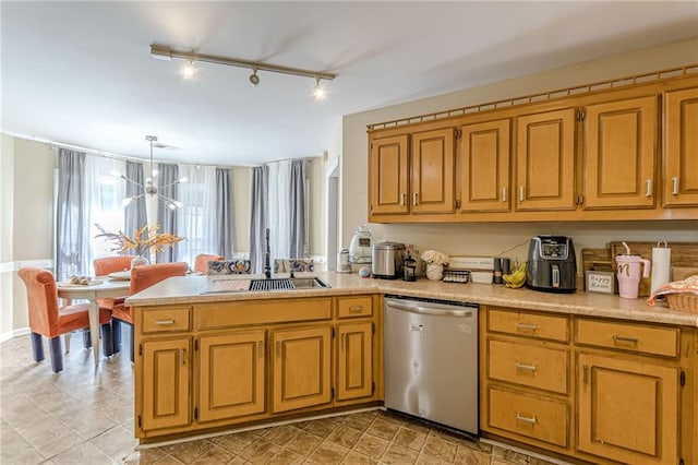 kitchen with kitchen peninsula, track lighting, hanging light fixtures, stainless steel dishwasher, and a notable chandelier