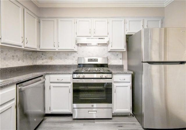 kitchen with light wood-style flooring, appliances with stainless steel finishes, ornamental molding, white cabinets, and under cabinet range hood