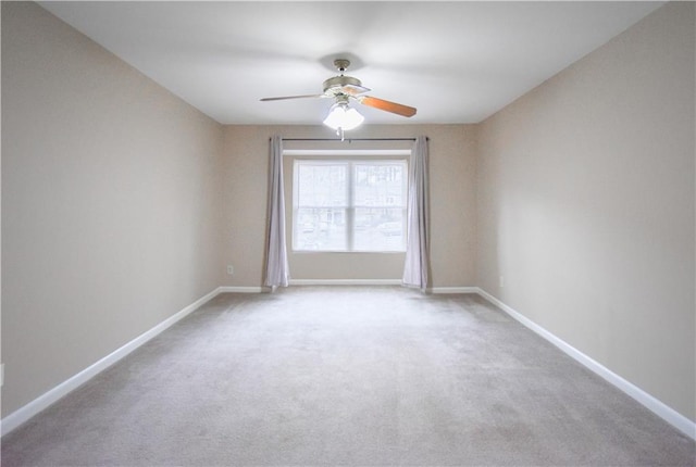 spare room featuring a ceiling fan, carpet flooring, and baseboards