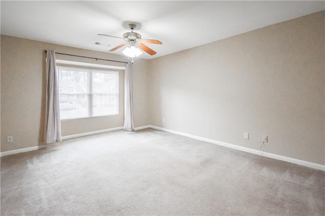 empty room with a ceiling fan, carpet, visible vents, and baseboards
