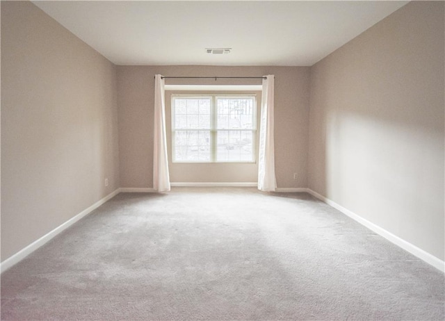 unfurnished room featuring carpet, visible vents, and baseboards