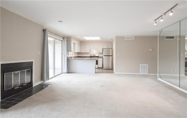 unfurnished living room featuring light carpet, a fireplace with flush hearth, and visible vents