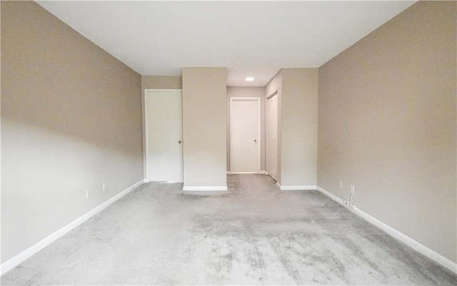carpeted empty room featuring baseboards