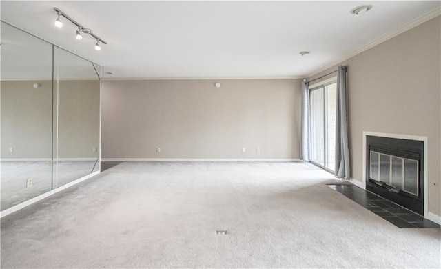 unfurnished living room featuring baseboards, carpet, a fireplace with flush hearth, and crown molding