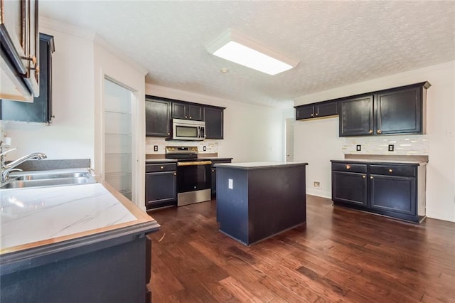 5900 Fairington Farms Ln, Stonecrest, GA 30038 - kitchen with appliances with stainless steel finishes, dark wood-style floors, backsplash, a center island, and a textured ceiling