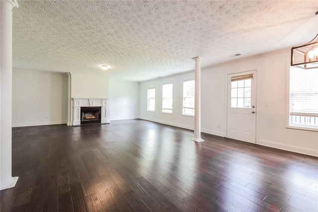 5900 Fairington Farms Ln, Stonecrest, GA 30038 - unfurnished living room featuring ornate columns, dark wood-style flooring, healthy amount of natural light, and a textured ceiling