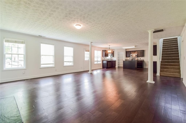 5900 Fairington Farms Ln, Stonecrest, GA 30038 - unfurnished living room featuring dark wood-style floors, a textured ceiling, stairs, and a chandelier