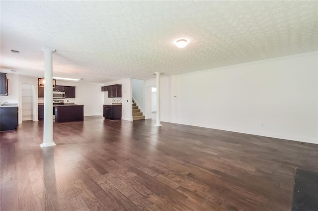 5900 Fairington Farms Ln, Stonecrest, GA 30038 - unfurnished living room with dark wood-type flooring, a textured ceiling, and stairway