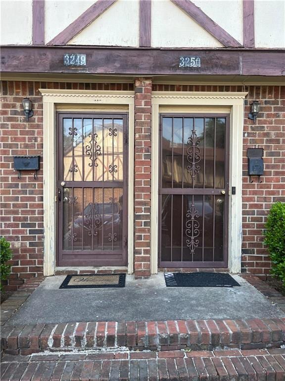 view of exterior entry featuring brick siding