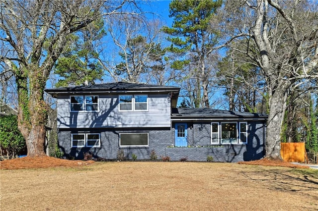 view of front of property featuring a front yard and brick siding