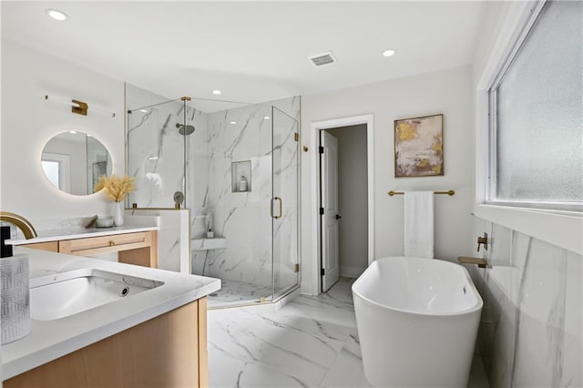 full bathroom with marble finish floor, a marble finish shower, recessed lighting, a freestanding bath, and vanity