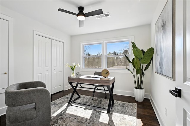 office featuring dark wood-style floors, visible vents, baseboards, and a ceiling fan