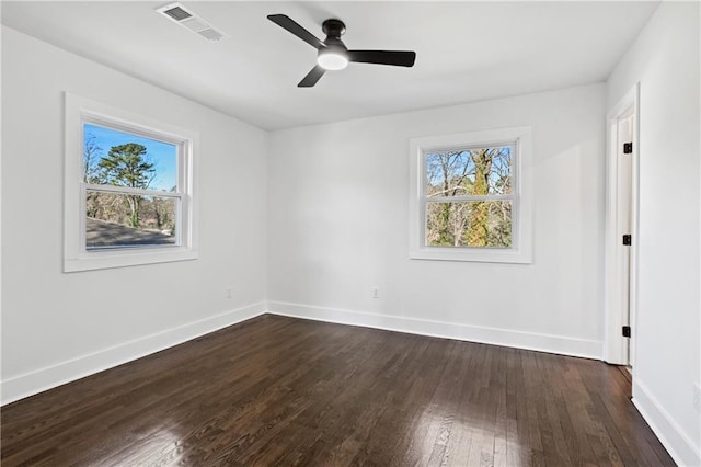 unfurnished bedroom featuring dark wood-style floors, visible vents, baseboards, and multiple windows