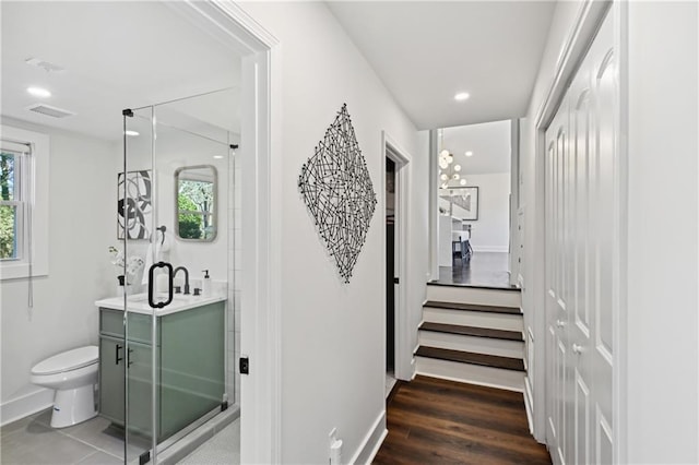 hallway featuring recessed lighting, wood finished floors, visible vents, and baseboards