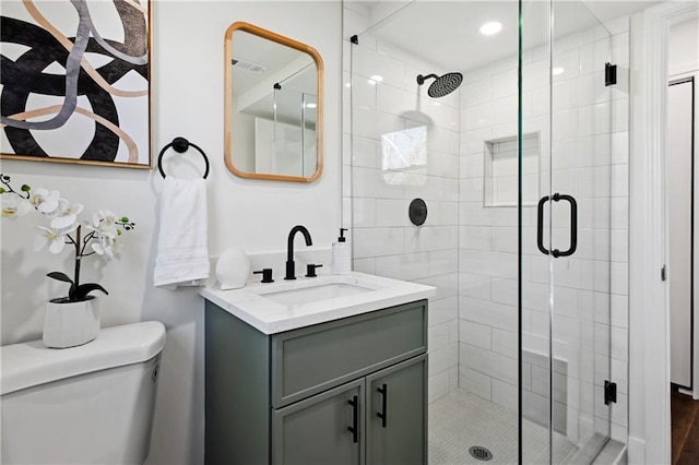 full bathroom with toilet, a shower stall, visible vents, and vanity