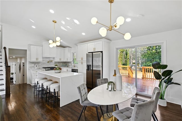 kitchen featuring tasteful backsplash, light countertops, white cabinetry, a kitchen island, and stainless steel fridge with ice dispenser