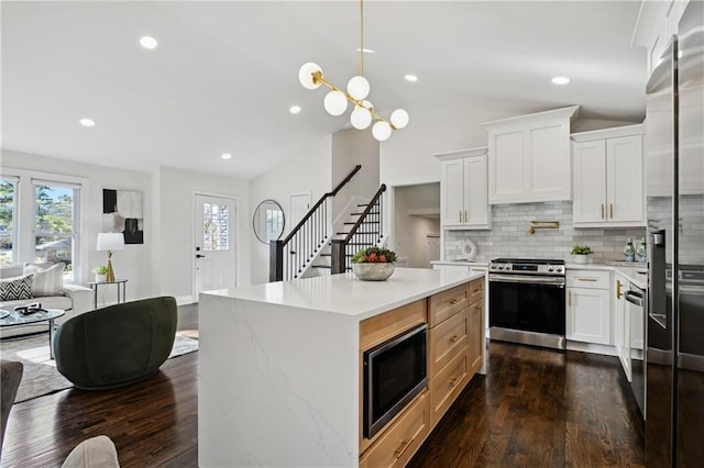 kitchen with backsplash, vaulted ceiling, stainless steel appliances, and dark wood-type flooring