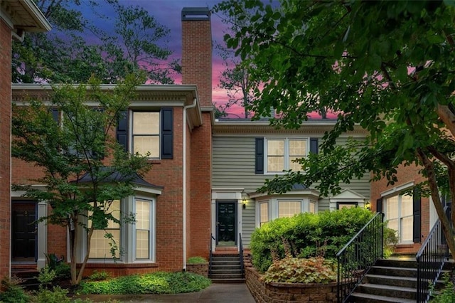 4 Mount Vernon Cir, Atlanta, GA 30338 - back of property at dusk featuring stairs, a chimney, and brick siding