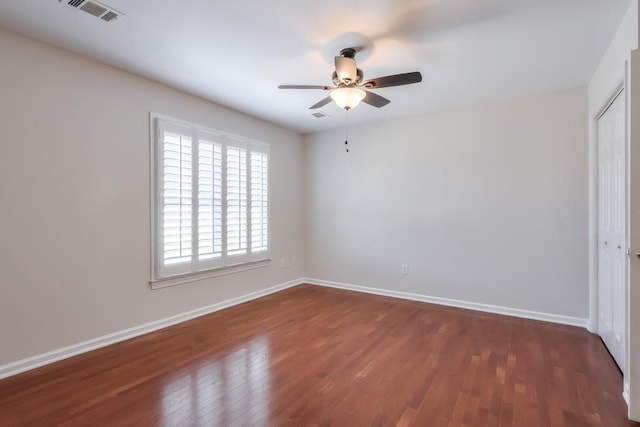 unfurnished bedroom featuring wood finished floors, a ceiling fan, visible vents, baseboards, and a closet