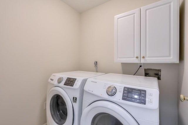 washroom with cabinet space and washing machine and dryer