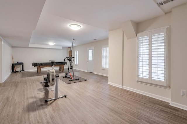 workout room with wood finished floors, visible vents, and baseboards