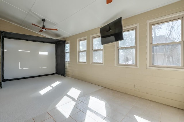 unfurnished room with a ceiling fan, a healthy amount of sunlight, and vaulted ceiling