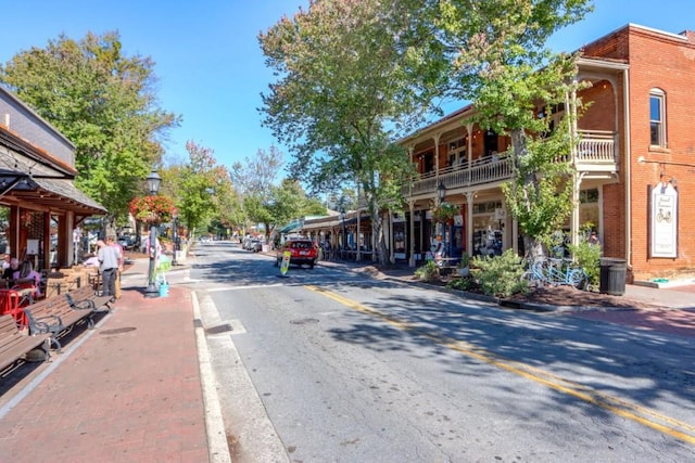 view of street featuring sidewalks, street lights, and curbs