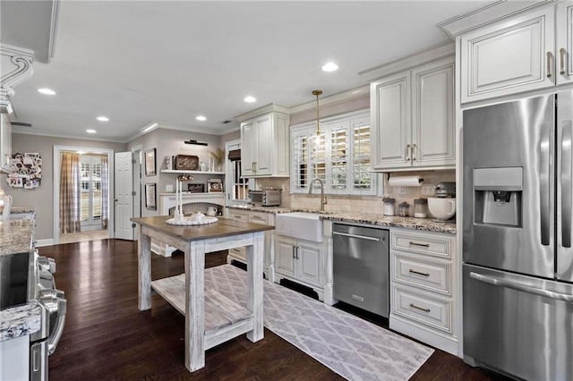 kitchen with hanging light fixtures, white cabinets, sink, and stainless steel appliances