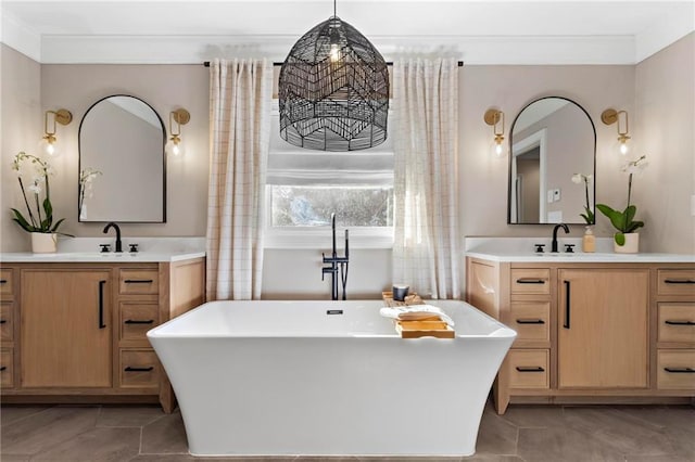 bathroom with a tub to relax in, vanity, and crown molding