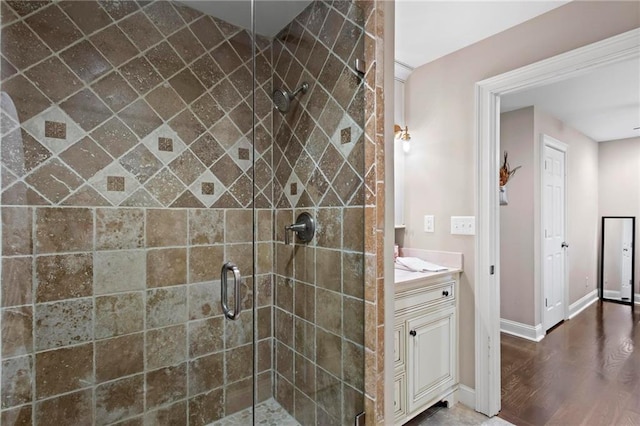 bathroom with hardwood / wood-style floors, an enclosed shower, and vanity