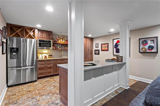 kitchen with sink, stainless steel appliances, and decorative columns