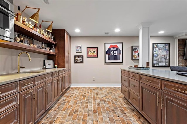 kitchen featuring sink, dark brown cabinets, and stainless steel oven